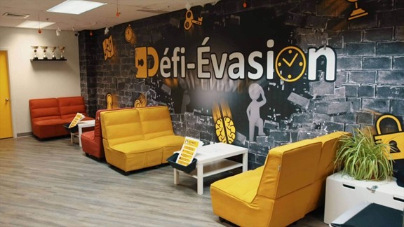 Défi-Évasion waiting room in Quebec City, with colorful sofas and immersive décor on the theme of escape games.